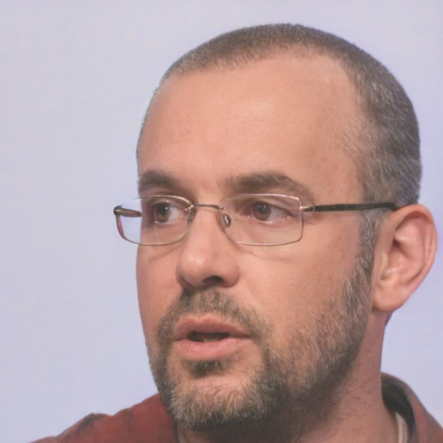 Senior financial educator reviewing business case studies during program development session